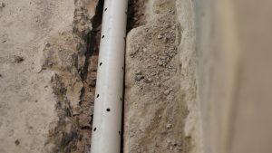 Drain tile installed along footing beneath basement floor