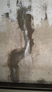 Patched foundation crack with staining from minerals