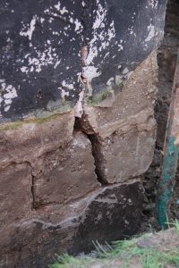 Broken cinder-block foundation wall with wide crack