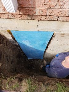 Peel and stick adhesive rubber membrane applied over a foundation crack