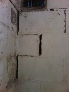 Cinder-blocks that have shifted with deteriorated mortar joints 