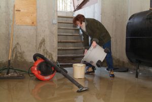 lady mopping up the water in her basement