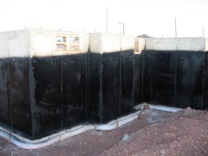 Damp-proof coating sprayed onto newly constructed foundation walls