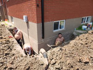 Photo of a waterproofing crew working in the hot sun